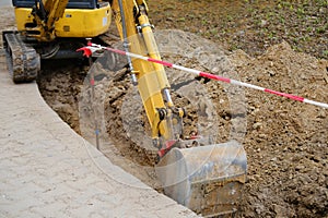 Escavatore secchio La terra fosso sul strade da riparazione urbano comunicazione gestione elettrico reti sul 