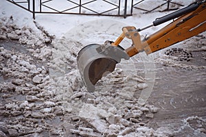 Excavator bucket digs heavy ice