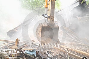 Excavator bucket in dust. Building demolition. Structure dismantling
