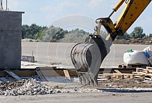 He excavator bucket is lowered to the ground