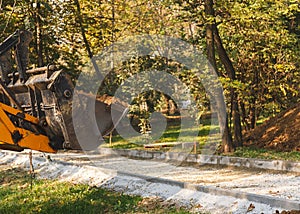 Excavator bucket moving earth. Forest road construction