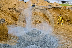 Excavator bucket moving gravel stones for foundation building