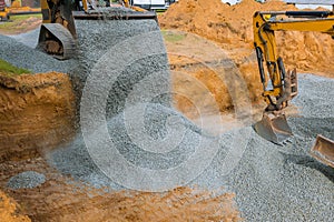 Excavator bucket moving gravel stones for foundation building