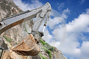 An excavator bucket on work in a granite mine