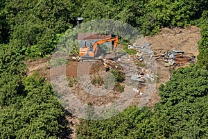 Excavator and builders destroy illegal buildings in the park