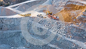 Excavator, bulldozer and conveyor machines on top of stone quarry