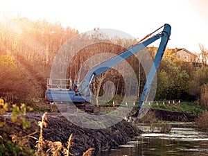 Excavator cleaning and deepening small river.