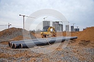 Excavator during construction of main water supply pipeline. Laying underground storm sewers at construction site. Water main