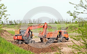 excavator in construction site on sunset sky background