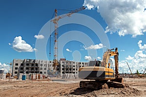Excavator at a construction site against the background of a tower crane. Construction, technology