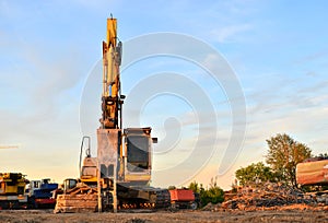 Excavator on a construction site cuts and crumbles old concrete and asphalt.