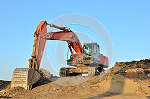 Excavator at a construction site during earthworks and laying of underground pipes.