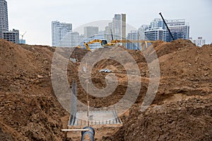 Excavator at construction site during laying sewer and main reticulation systems. Civil infrastructure pipe, water lines, sanitary