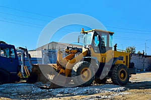 Excavator on the construction site is preparing to load the soil into the dump truck. Wheel loader with iron bucket