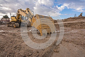 Excavator at the construction site of a road, moving earth