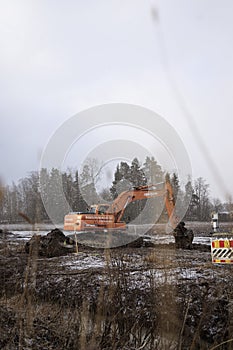 Excavator and construction site in a snowstorm
