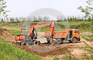excavator in construction site on sunset sky background