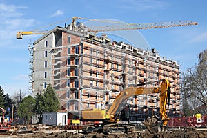 Excavator and cranes on building construction site