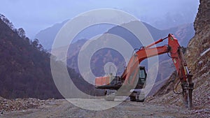 Excavator crushes stones in the mountains