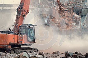 Excavator demolishes an old building with special equipment