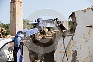 Excavator demolishing a concrete wall