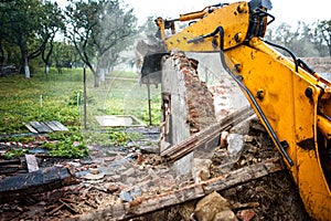 Excavator demolishing a concrete wall
