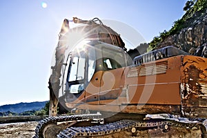 Excavator with demolition hammer in a Carrara marble quarry.
