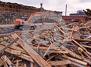 Excavator at demolition site breaking down the building