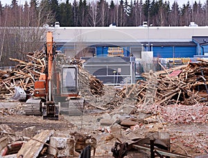 Excavator at demolition site breaking down the building