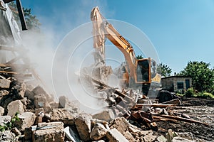 Excavator destroy old house. Demolition of building