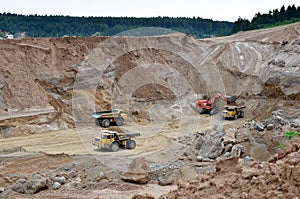 Excavator developing the sand on the opencast and loading it to the heavy dump truck. Processing of loose material in mining