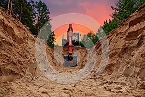 Excavator dig trench at forest area on amazing sunset background. Backgoe on earthwork for laying crude oil and natural gas