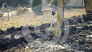 Excavator is digging foundations of house. Excavating of hole. Construction machinery, ground works. Digger works on building. Buc