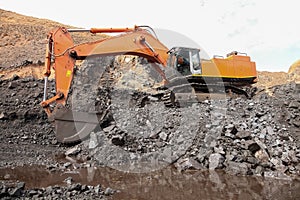 Excavator digging ore rocks at a Manganese mine