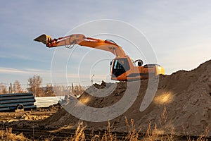 Excavator digging trench using dump truck. earthworks at construction site. heavy earth mover machine