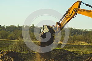 Excavator digs the ground. part of construction earthmoving equipment. digging the soil with an excavator bucket