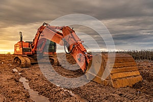 Excavator doing work on a wet and muddy winter day