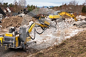 Excavator and drilling machine outdoors on construction site