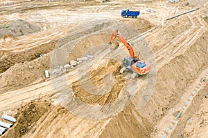 Excavator and dump truck working at construction site