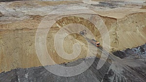 Excavator and dumper truck. Aerial view of loading sand into a truck. A heavy machinery - excavator and truck are