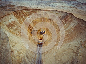 Excavator and dumper truck. Aerial view of loading sand into a truck. A heavy machinery - excavator and truck are