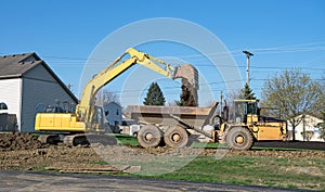 Excavator Dumping Soil into Dump Truck