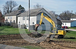 Excavator Dumping Soil on Pile in Early Morning Light