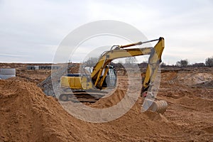 Excavator during earthmoving at construction site. Backhoe digg ground at construction site for the construction of the