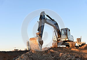 Excavator during earthmoving at construction site. Backhoe digg ground at construction site for the construction of the road and