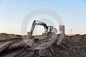 Excavator during earthmoving at construction site. Backhoe digg ground at construction site for the construction of the road and