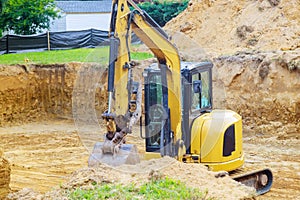 Excavator during earthmoving work at foundation pit for construction of underground photo