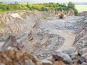 Excavator during earthmoving work at open-pit mining on gravel quarry