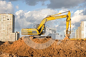 Excavator during Earthmoving Works at construction site. Backhoe digs the foundations of the building