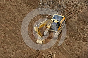 Excavator on earthworks. Backhoe on groundwork for road construction. Digger at construction site. Loader in open pit mining.